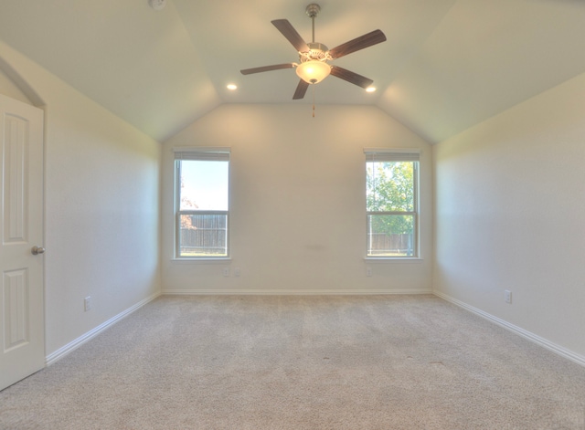 carpeted spare room featuring vaulted ceiling, plenty of natural light, and ceiling fan