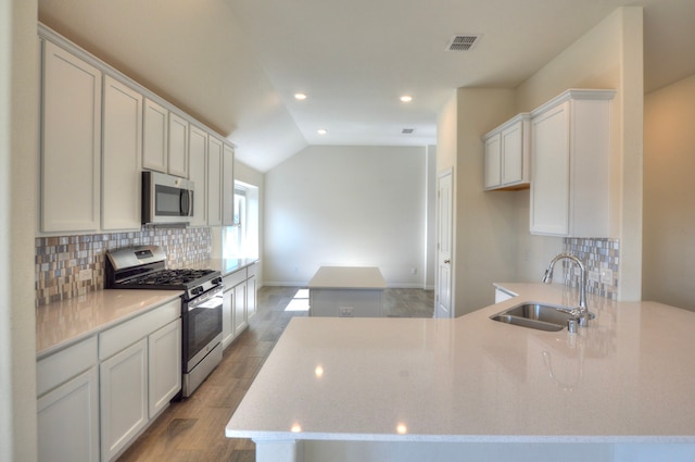 kitchen with white cabinetry, sink, lofted ceiling, appliances with stainless steel finishes, and light wood-type flooring