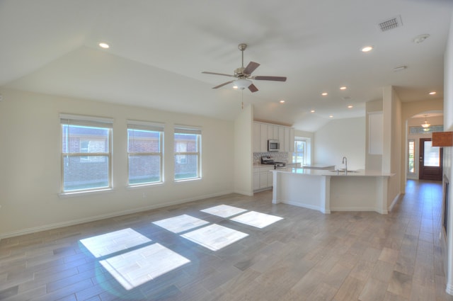 kitchen with white cabinets, light wood-type flooring, kitchen peninsula, and a wealth of natural light