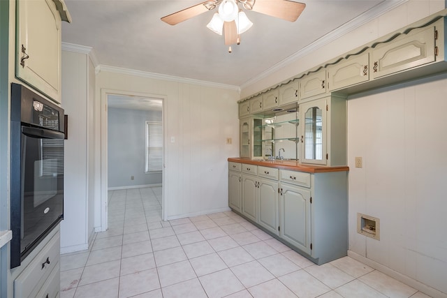 kitchen featuring light tile patterned flooring, ceiling fan, ornamental molding, and sink