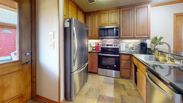 kitchen with decorative backsplash, sink, and appliances with stainless steel finishes