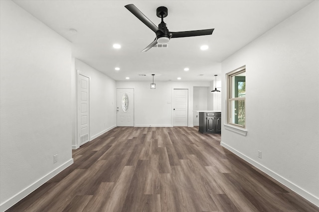 unfurnished living room with dark wood-type flooring and ceiling fan