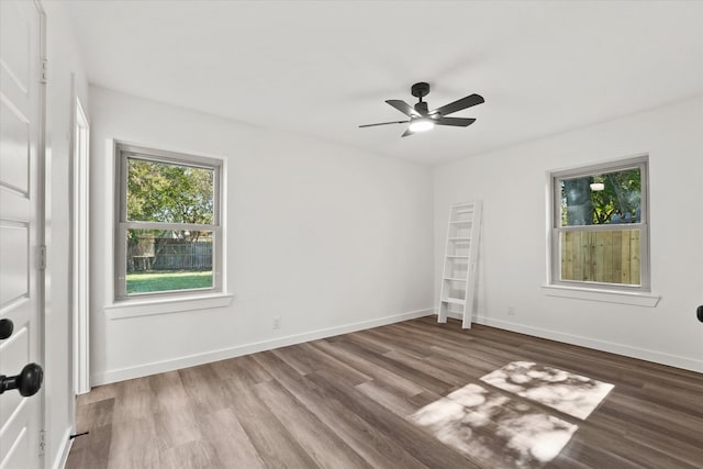 unfurnished room with ceiling fan, plenty of natural light, and dark hardwood / wood-style floors