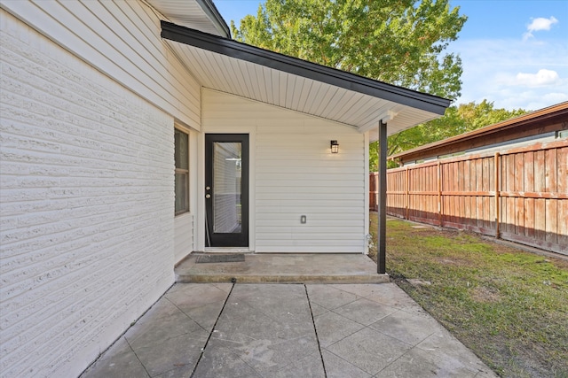 view of exterior entry with a patio