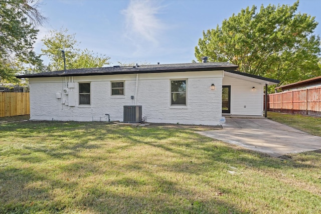 rear view of property featuring central AC unit, a patio area, and a lawn