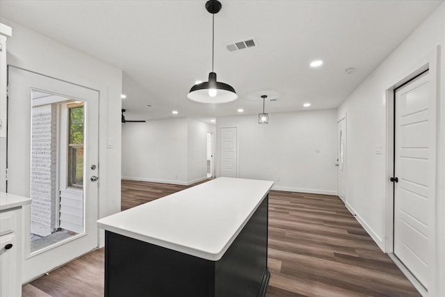 kitchen with pendant lighting, a center island, and dark wood-type flooring