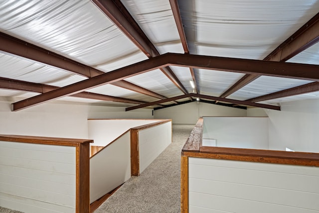 additional living space with lofted ceiling with beams and light colored carpet