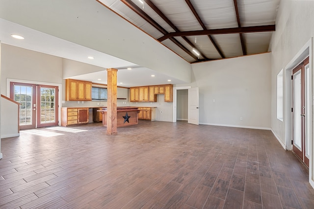 unfurnished living room featuring french doors, high vaulted ceiling, and hardwood / wood-style floors