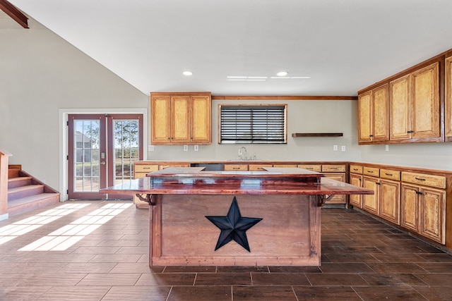 kitchen featuring a kitchen bar, french doors, lofted ceiling, and sink