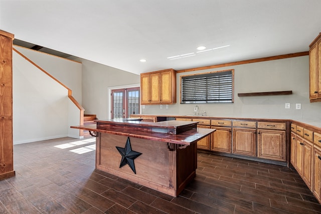 kitchen featuring a kitchen breakfast bar, a center island, dark wood-type flooring, and sink