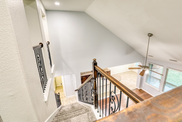 stairway featuring hardwood / wood-style floors, ceiling fan, and lofted ceiling