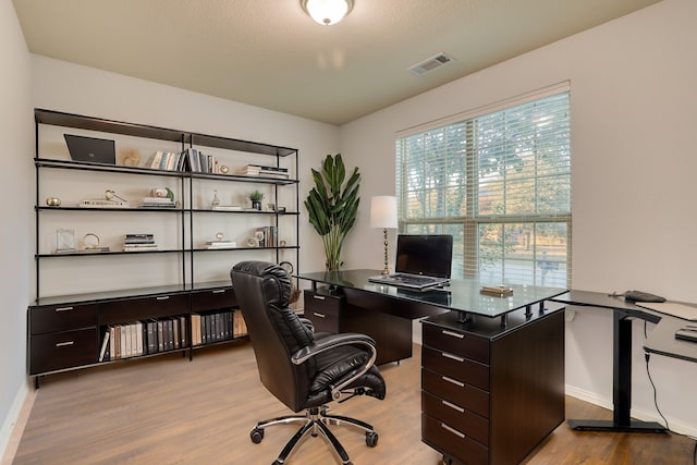 office space featuring a textured ceiling and light hardwood / wood-style flooring