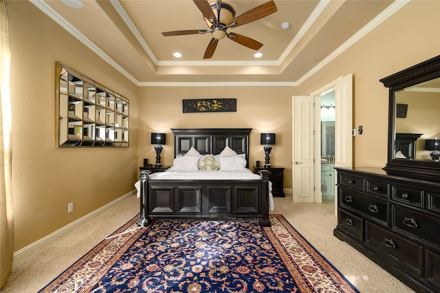 bedroom with light carpet, ensuite bath, ornamental molding, a tray ceiling, and ceiling fan