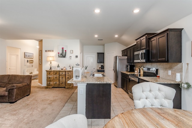 kitchen with light carpet, stainless steel appliances, light stone countertops, and sink