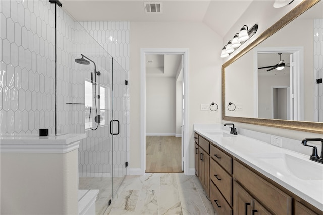 bathroom featuring a shower with door and vanity