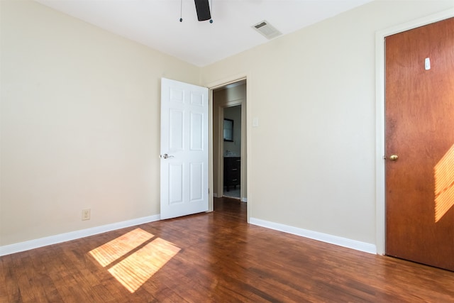 spare room featuring ceiling fan and dark wood-type flooring