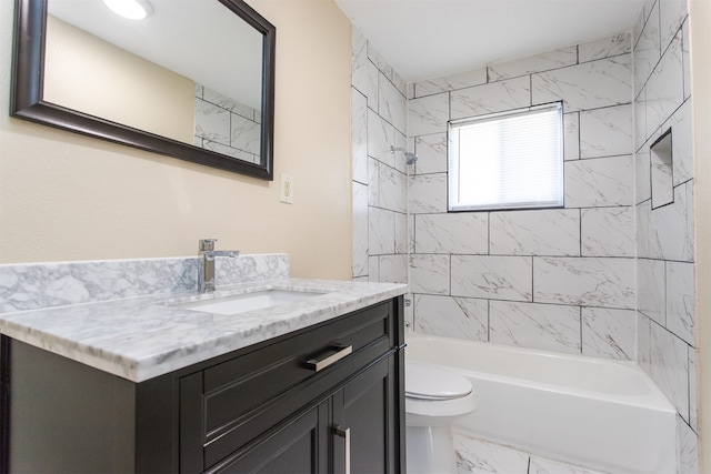 full bathroom featuring vanity, tiled shower / bath combo, and toilet