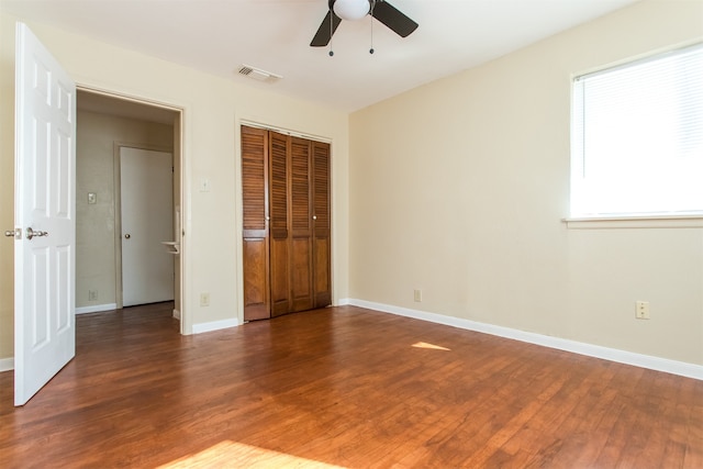 unfurnished bedroom featuring a closet, dark hardwood / wood-style floors, and ceiling fan