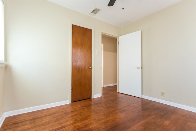 unfurnished bedroom featuring ceiling fan and dark hardwood / wood-style floors