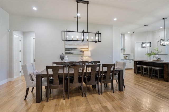 dining space featuring a notable chandelier and light wood-type flooring