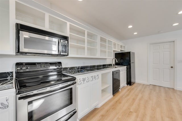 kitchen with black appliances, light hardwood / wood-style floors, white cabinets, and sink