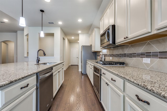 kitchen featuring white cabinetry, sink, stainless steel appliances, light stone counters, and dark hardwood / wood-style flooring