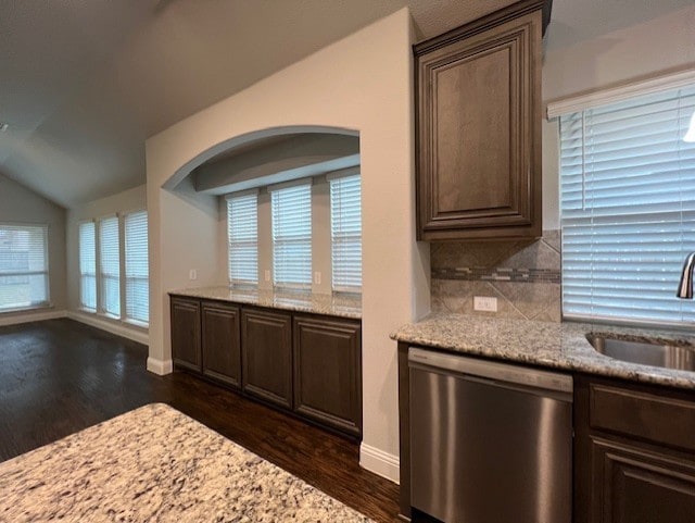 kitchen with sink, stainless steel dishwasher, and light stone countertops