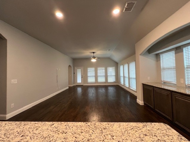 unfurnished living room with ceiling fan, dark hardwood / wood-style flooring, and vaulted ceiling