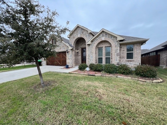 view of front of house featuring a garage and a front lawn