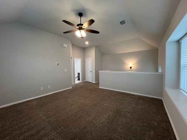 additional living space featuring ceiling fan, dark carpet, and vaulted ceiling