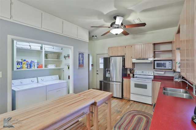 kitchen with stainless steel appliances, ceiling fan, sink, light hardwood / wood-style flooring, and independent washer and dryer