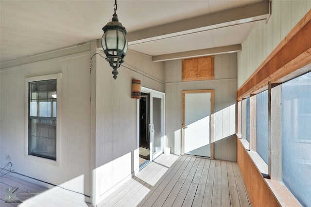 unfurnished sunroom with beamed ceiling