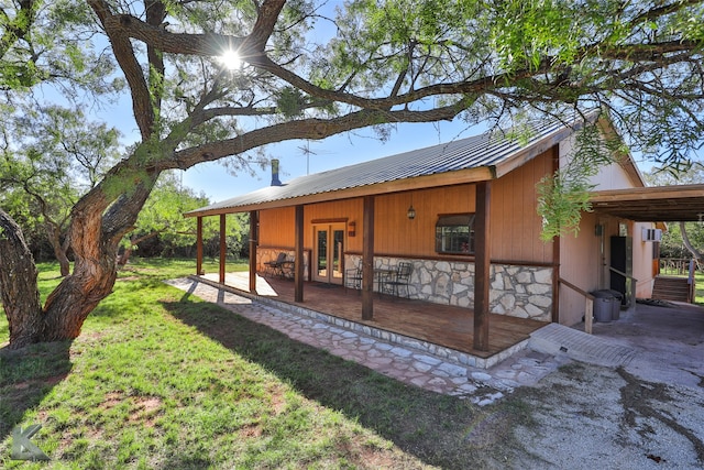 view of side of home featuring french doors and a yard