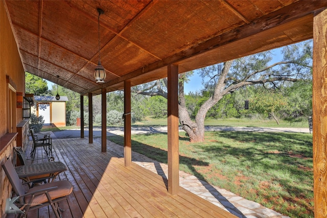 wooden terrace with an outdoor structure and a lawn