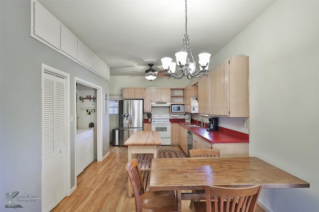 dining space featuring sink, ceiling fan with notable chandelier, and light wood-type flooring