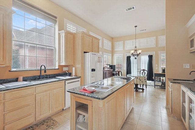 kitchen featuring a center island, white appliances, sink, and a wealth of natural light