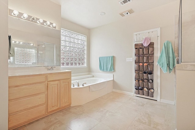 bathroom with vanity, tile patterned flooring, and plus walk in shower