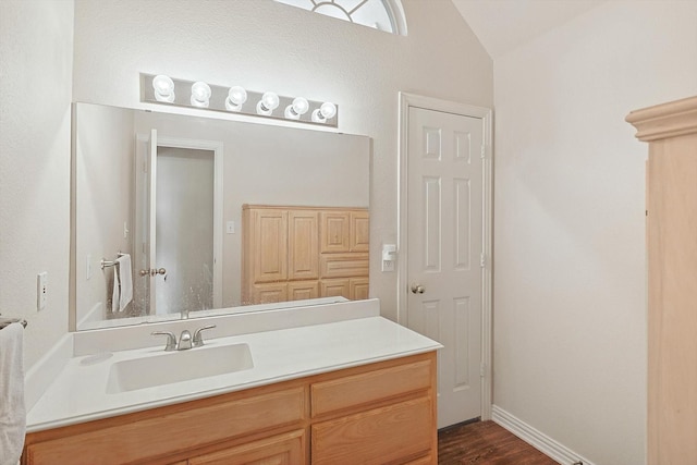 bathroom with vanity, wood-type flooring, and vaulted ceiling