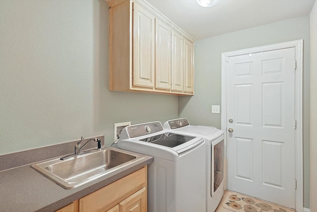 laundry area featuring washer and dryer, sink, and cabinets