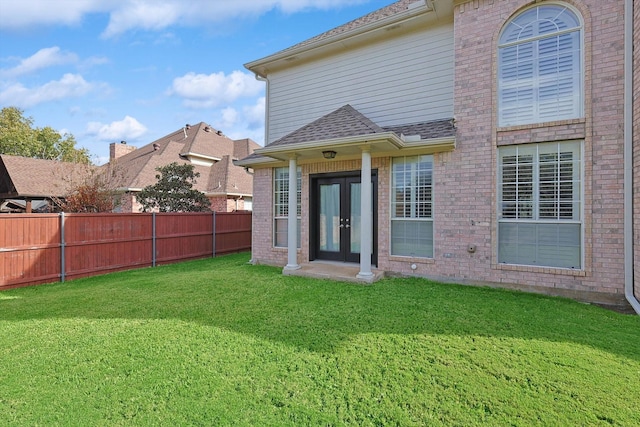 rear view of property featuring french doors and a lawn