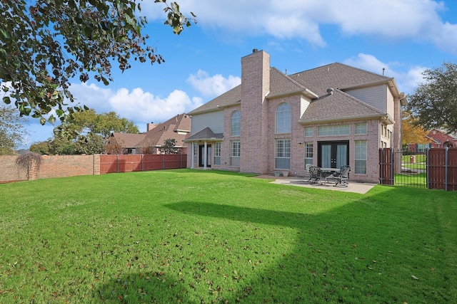 back of house with a lawn, a patio, and french doors