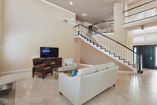 living room featuring ceiling fan and a towering ceiling