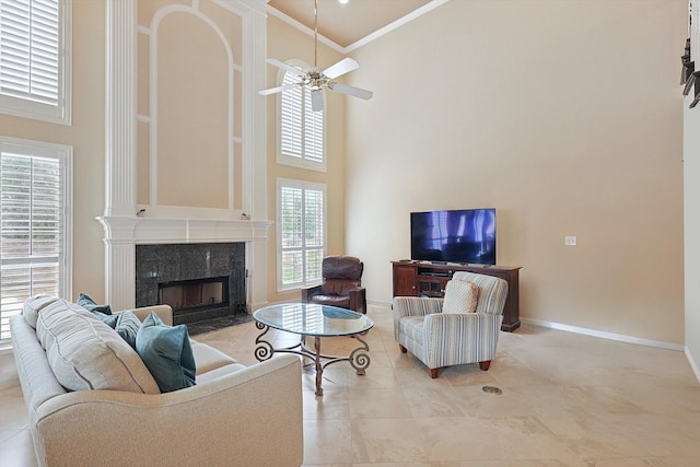 living room featuring a healthy amount of sunlight, a towering ceiling, and ornamental molding