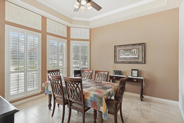 tiled dining room with ceiling fan and crown molding