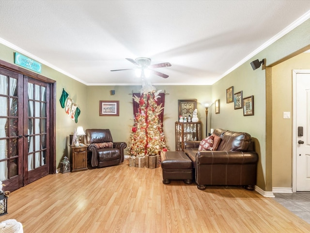 living room featuring french doors, ornamental molding, and light wood-type flooring