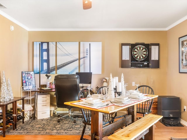 dining area with crown molding and hardwood / wood-style flooring