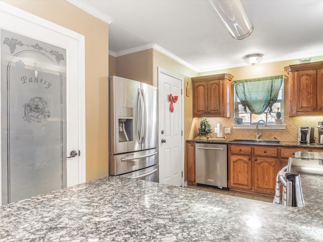 kitchen featuring backsplash, crown molding, sink, and appliances with stainless steel finishes