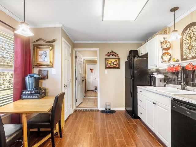 kitchen featuring black appliances, white cabinets, sink, light hardwood / wood-style flooring, and decorative light fixtures