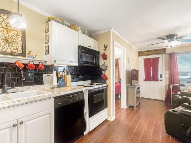 kitchen with sink, black appliances, wood-type flooring, decorative light fixtures, and white cabinets