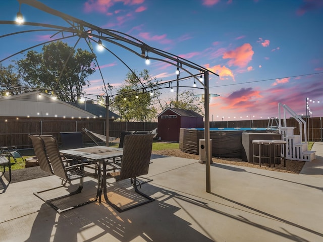 patio terrace at dusk featuring a shed